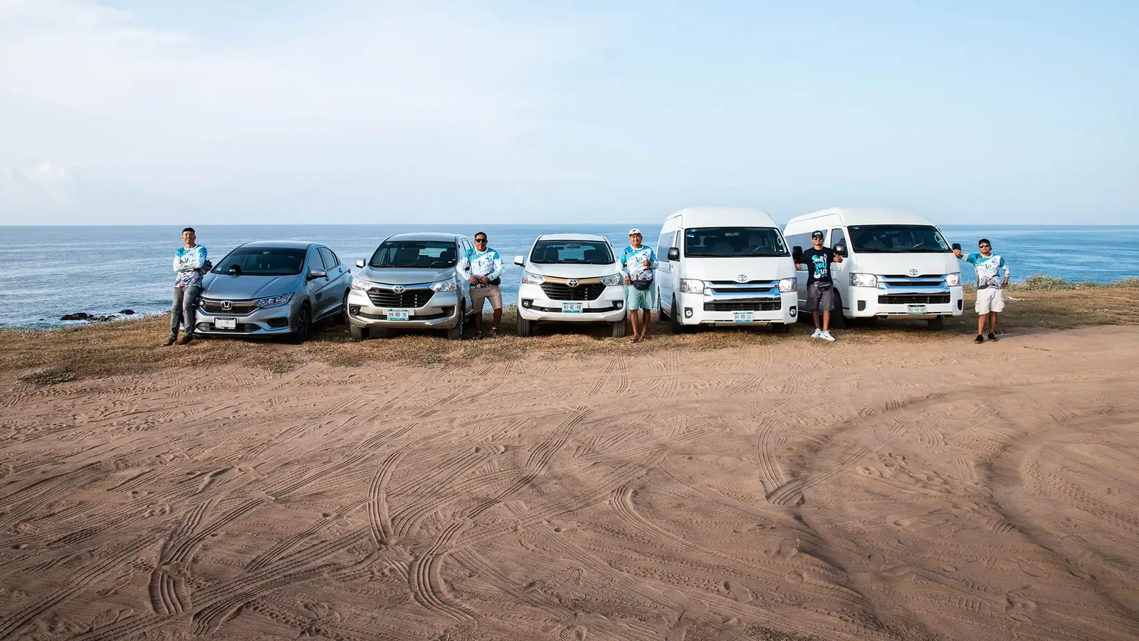 Equipo de conductores de Eco Adventures junto a sus vehículos en la costa de Oaxaca